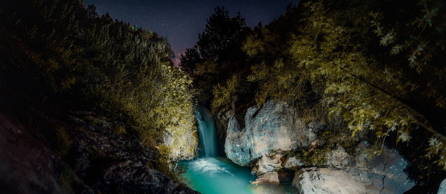 La cascada de les Dous de nit, amb l’aigua turquesa sota un cel estrellat