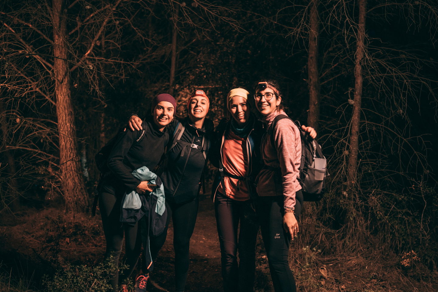 Grupo de cinco corredores con frontal riendo en el bosque