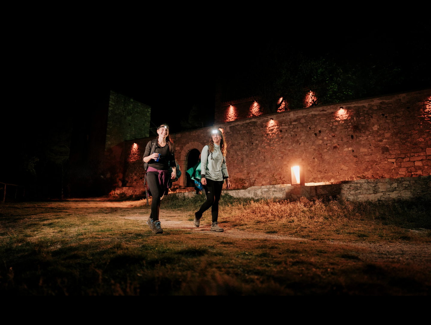 Caminantes con frontal junto al muro de velas del Santuario
