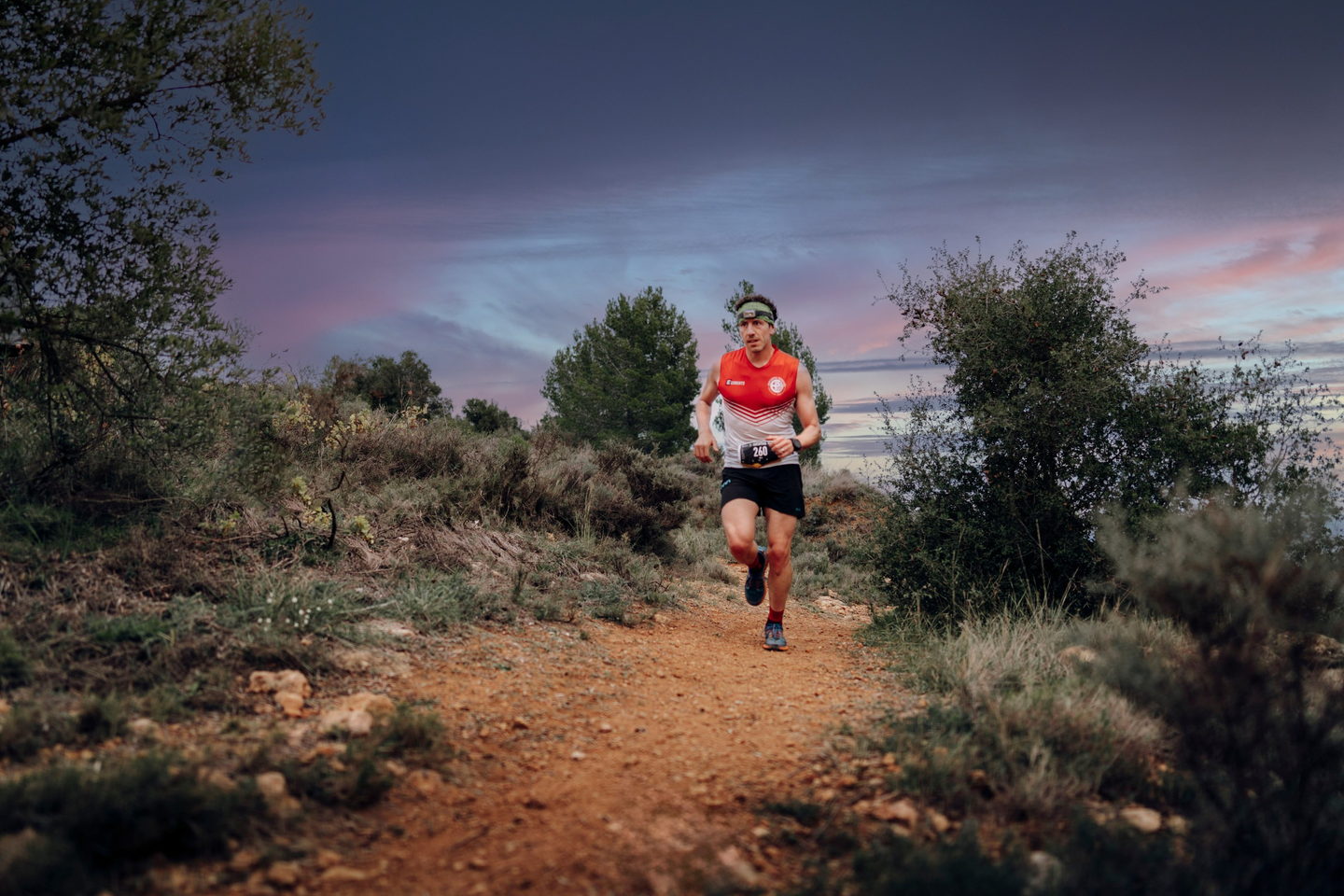 Dos corredores con frontal por el bosque de noche